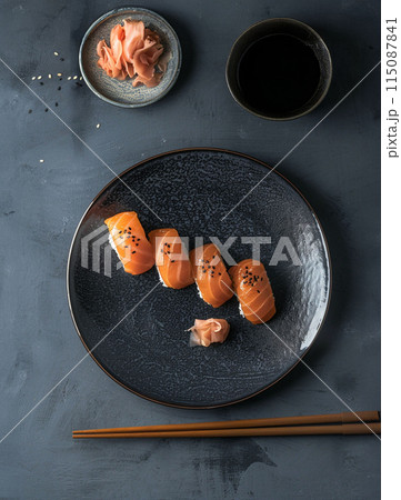Sushi set with wasabi and ginger on black stone tray on black table. Top view. 115087841