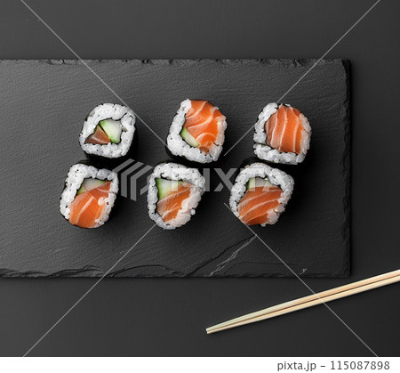 Sushi set with wasabi and ginger on black stone tray on black table. Top view. 115087898