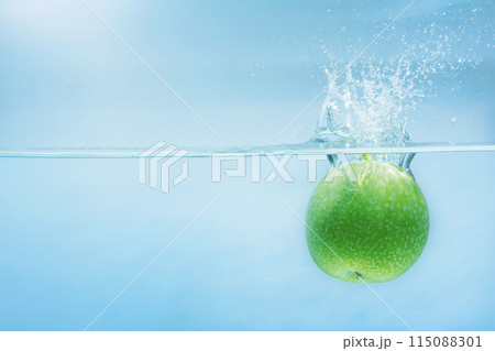 Green ripe apple falling on water surface, concept of refreshment and relaxation in health care 115088301