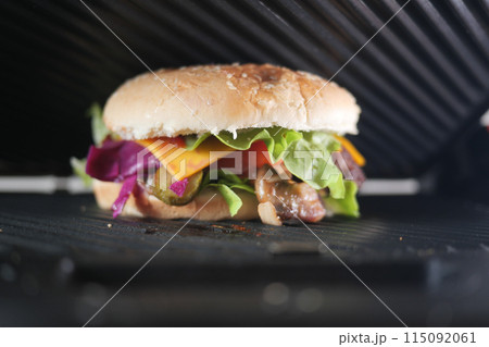 Sandwich with meatballs, lettuce, and red cabbage grilling at home Sandwich with meatballs, lettuce, and red cabbage grilling at home 115092061