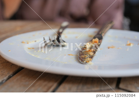 An empty dirty plate with a fork. 115092084