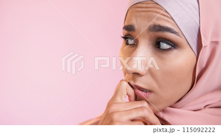 Scared face. Fear anxiety. Concerned expression. Overwhelmed worried confused pensive woman in hijab isolated on pink empty space background. Scared face. Fear anxiety. Concerned expression. Overwhelmed worried confused pensive woman in hijab isolated on pink empty space background. 115092222