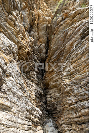 Narrow Rocky Cleft in a Cliff 115093577