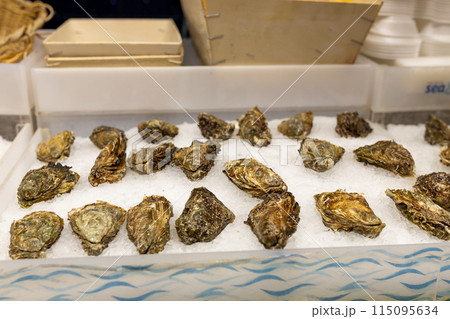 Fresh Oysters on the counter on ice in store. Oysters for sale at the seafood market. Aphrodisiac sea restaurant, expensive fresh food, dish menu 115095634