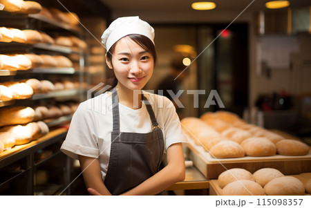 ベーカリーショップでパンを焼く若い女性スタッフ ベーカリーショップでパンを焼く若い女性スタッフ 115098357