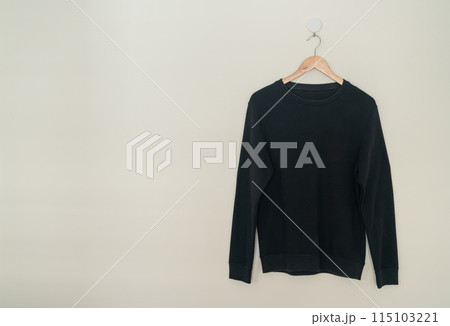 black sweater hanging on hanger 115103221