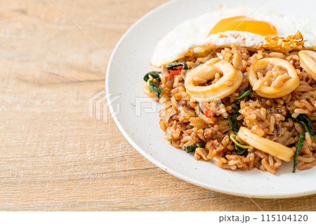 fried rice with squid and basil topped fried egg in Thai style fried rice with squid and basil topped fried egg in Thai style 115104120