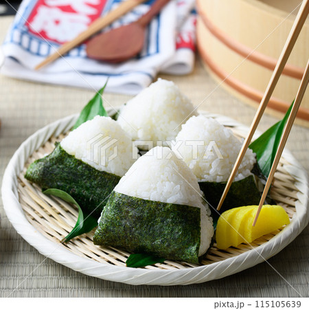 畳の上で食べる焼き海苔を巻いたおにぎりと昔ながらの酸っぱい梅干し 115105639