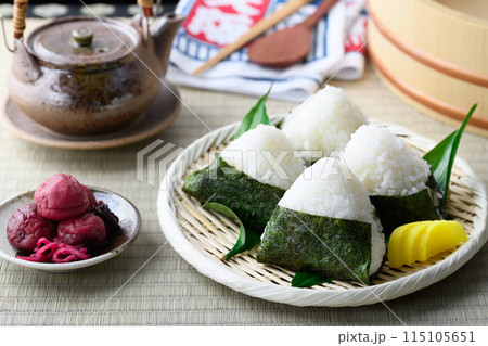 畳の上で食べる焼き海苔を巻いたおにぎりと昔ながらの酸っぱい梅干し 115105651