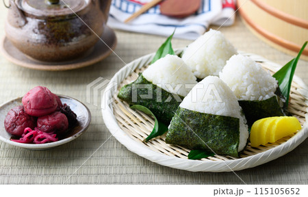 畳の上で食べる焼き海苔を巻いたおにぎりと昔ながらの酸っぱい梅干し 115105652