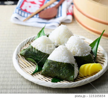 畳の上で食べる焼き海苔を巻いたおにぎりと昔ながらの酸っぱい梅干し 115105654