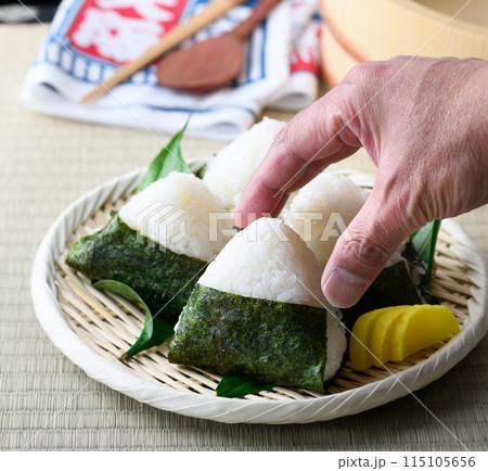 畳の上で食べる焼き海苔を巻いたおにぎりと昔ながらの酸っぱい梅干し 115105656