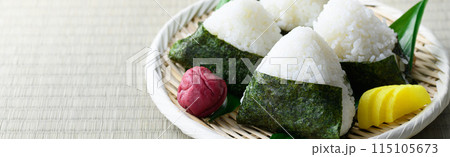 畳の上で食べる焼き海苔を巻いたおにぎりと昔ながらの酸っぱい梅干し 115105673