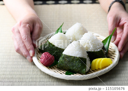 畳の上で食べる焼き海苔を巻いたおにぎりと昔ながらの酸っぱい梅干し 畳の上で食べる焼き海苔を巻いたおにぎりと昔ながらの酸っぱい梅干し 115105676