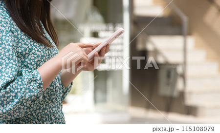 街角でスマホを操作する若い女性 街角でスマホを操作する若い女性 115108079