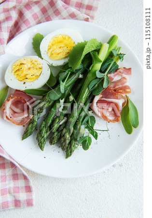 Fresh Asparagus and Prosciutto Salad Served With Boiled Eggs and Microgreens 115108111