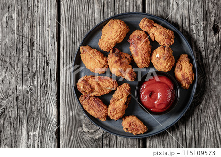 american style fried chicken wings on a plate 115109573