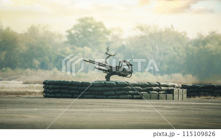 An anti-aircraft cannon and Military fighting scene. Piece of an anti-aircraft artillery batteries against, World War Soldiers Below Cloudy Skyline at sunset. Attack scene. An anti-aircraft cannon and Military fighting scene. Piece of an anti-aircraft artillery batteries against, World War Soldiers Below Cloudy Skyline at sunset. Attack scene. 115109826