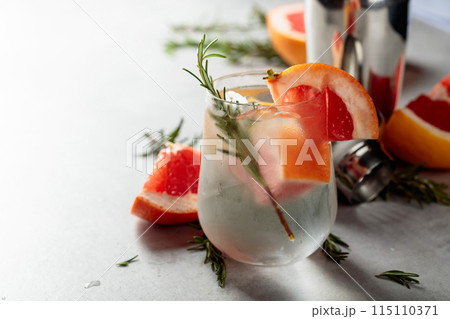 Refreshing drink with natural ice, grapefruit, and rosemary in a frozen glass. 115110371