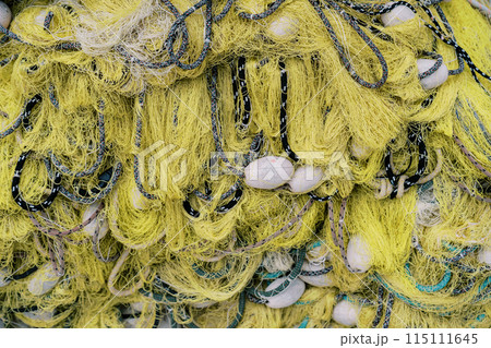 Yellow fishing net with black ropes and white floats. Top view Yellow fishing net with black ropes and white floats. Top view 115111645