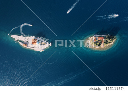 Boats sail around the islands of Gospa od Skrpjela and St. George. Montenegro. Drone 115111874