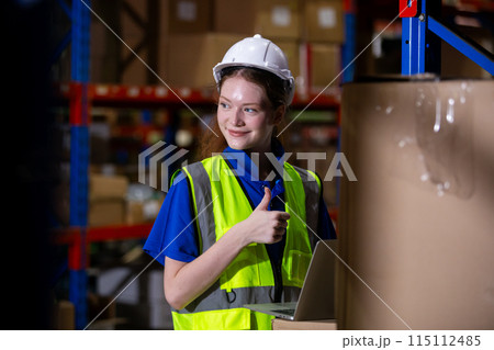 Female worker wearing safety uniform and hard hat using laptop Female worker wearing safety uniform and hard hat using laptop 115112485