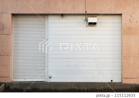 A closeup shot of automatic metal roller door used in factory, storage, garage, and industrial warehouse. The corrugated and foldable metal sheet offer space saving and provide urban and rustic feel 115112635