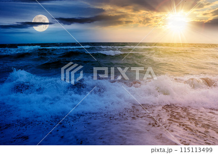 dramatic seascape at summer solstice. waves crashing the shore beneath a sky with sun and moon above horizon. day and night time change concept 115113499