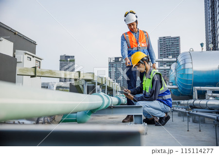 Asian man engineer holding tablet working at rooftop building construction. Asian man engineer holding tablet working at rooftop building construction. 115114277
