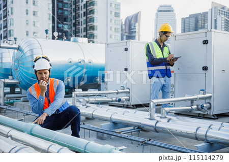 Asian man engineer using talkie walkie report working at rooftop building construction. Asian man engineer using talkie walkie report working at rooftop building construction. 115114279