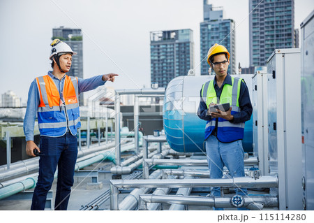 Asian man engineer using talkie walkie report working at rooftop building construction. 115114280