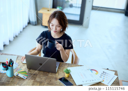 自宅でパソコンに向かって仕事をする女性デザ 115115746