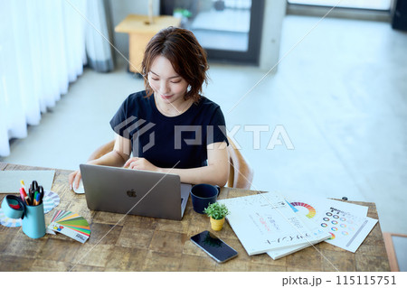 自宅でパソコンに向かって仕事をする女性デザ 115115751