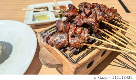 Homemade lamb or mutton satay marinated with spice and sweet soy sauce, coriander goat satay, served with chilli, soy sauce and tomato. Indonesian traditional satay 115118426