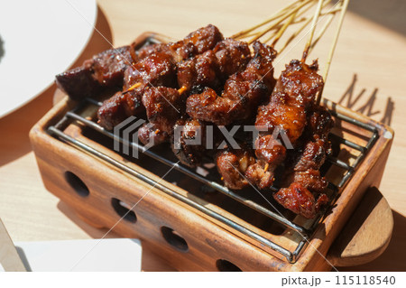 Homemade lamb or mutton satay marinated with spice and sweet soy sauce, coriander goat satay, served with chilli, soy sauce and tomato. Indonesian traditional satay 115118540