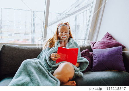 portrait middle-aged woman with cosmetic mask on face on sofa at home portrait middle-aged woman with cosmetic mask on face on sofa at home 115118847