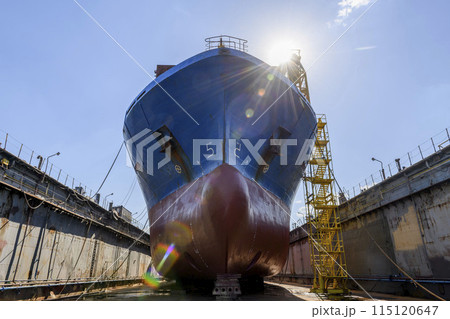 Cargo vessel in dry dock on ship repairing yard. Bulbous bow. 115120647