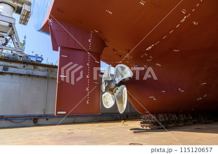 Cargo vessel in dry dock on ship repairing yard. Variable pitch propeller and rudder. Cargo vessel in dry dock on ship repairing yard. Variable pitch propeller and rudder. 115120657