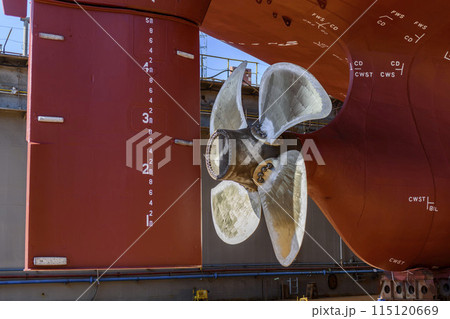 Cargo vessel in dry dock on ship repairing yard. Variable pitch propeller and rudder. Cargo vessel in dry dock on ship repairing yard. Variable pitch propeller and rudder. 115120669