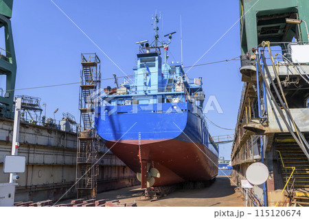 Cargo vessel in dry dock on ship repairing yard. Variable pitch propeller and rudder. Cargo vessel in dry dock on ship repairing yard. Variable pitch propeller and rudder. 115120674