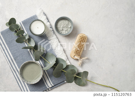 Organic cosmetic clay for face, brush, candle and eucalyptus branch on a white textured background Organic cosmetic clay for face, brush, candle and eucalyptus branch on a white textured background 115120763