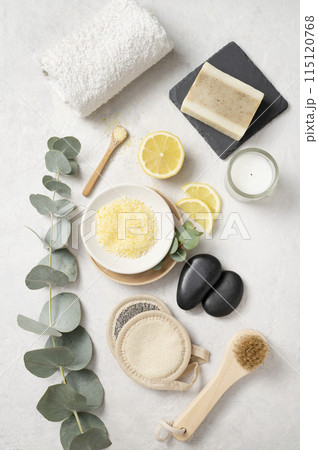 Flat lay organic yellow sea salt with lemon, soap, massage stone, brush, towel, sponge Flat lay organic yellow sea salt with lemon, soap, massage stone, brush, towel, sponge 115120768