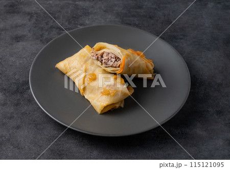 Delicious cabbage roll with meat pork, beef or chicken on a plate on a dark  isolated background 115121095