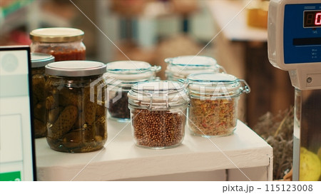 Cereals and grains in reusable jars placed on checkout counter at local eco supermarket, low carbon footprint locally grown merchandise. Organic fresh chemicals free products in store. Close up. 115123008