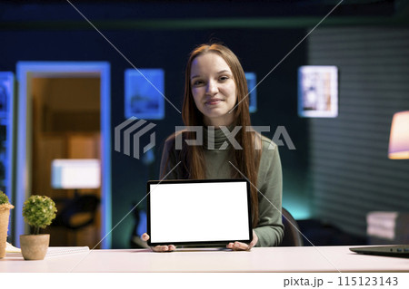 Smiling girl presenting mockup tablet in entry level low budget price range. Upbeat gen Z content creator reviewing isolated screen digital device in front of internet fanbase 115123143