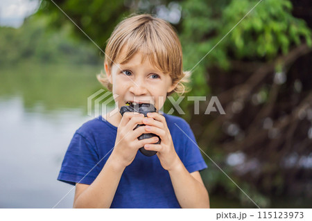 Boy eating Vietnamese Pork Banh Mi Sandwich in a black baguette Boy eating Vietnamese Pork Banh Mi Sandwich in a black baguette 115123973