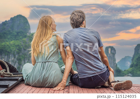 Man and woman travelers is traveling by boat in Halong Bay. Vietnam. Travel to Asia, happiness emotion, summer holiday concept. After COVID 19. Picturesque sea landscape. Ha Long Bay, Vietnam 115124035