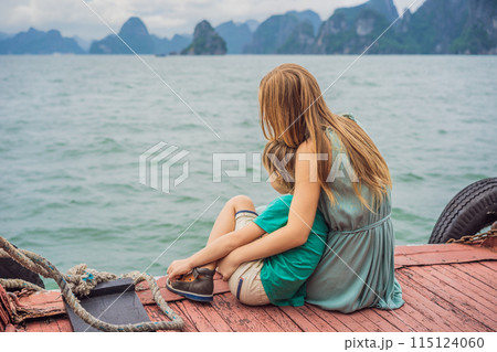 Mom and son travelers is traveling by boat in Halong Bay. Vietnam. Travel to Asia, happiness emotion, summer holiday concept. Traveling with children concept. After COVID 19. Picturesque sea landscape 115124060