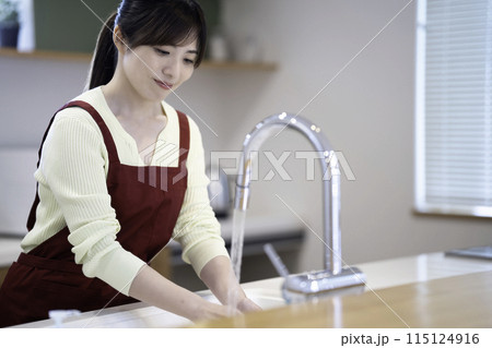 洗い物をするエプロンをした主婦 115124916