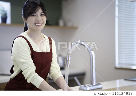 洗い物をするエプロンをした主婦 115124918